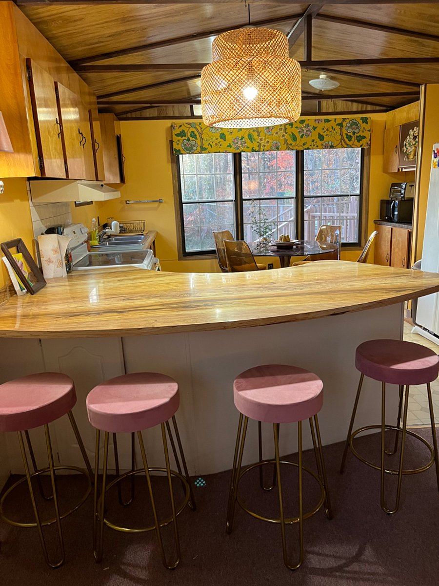 The living room and kitchen is divided by this fun bar.