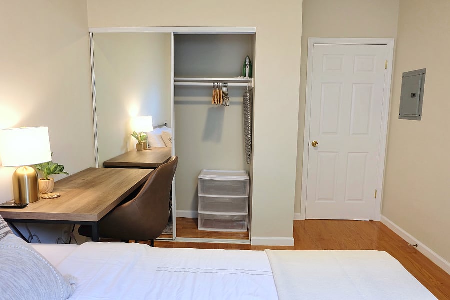 Full sized closet with mirrored doors. Iron and ironing board inside