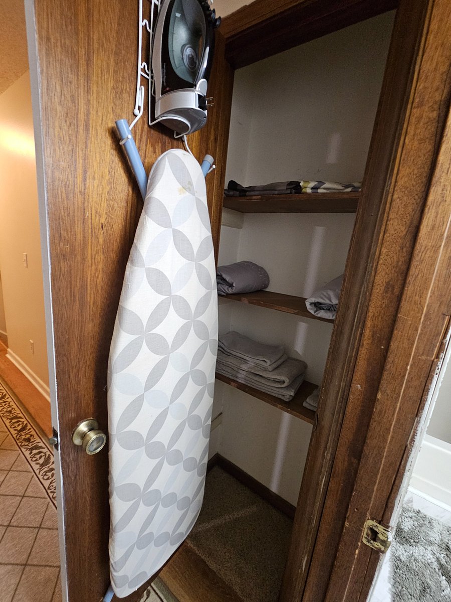 Extra sheets, towels, ironing board and iron in the linen closet.