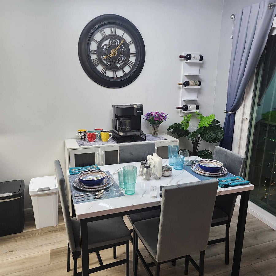 Dinning area with coffee bar, wine glasses (in cupboard) along with linen napkins and variety of placemats.