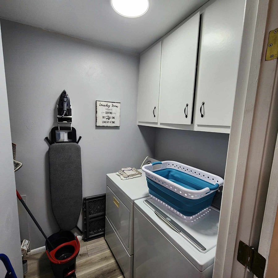 Laundry room with washer/dryer, full size ironing board and iron.