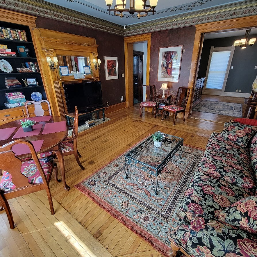 Living/Dining room is right off the kitchen on the main floor and is connected to the entryway and gallery. The dining table seats 4 people, however there are two extra chairs for additional people.