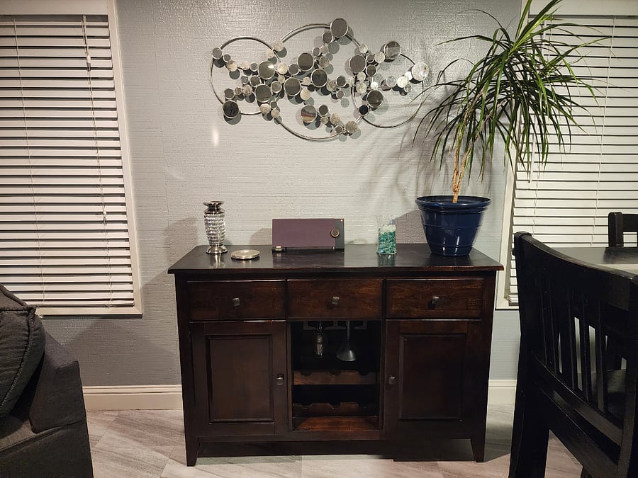 Cabinet with wine glasses and other drink glasses. Bluetooth capable speaker.