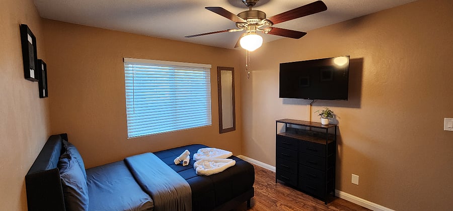 Bedroom #2 - Double size bed, ceiling fan, smart TV, desk, closet, and dresser.