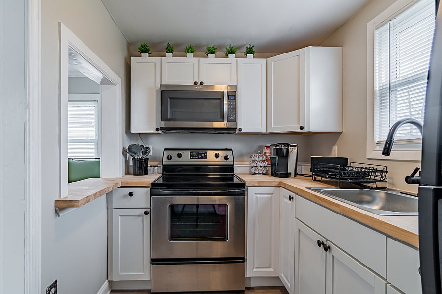 Full kitchen with Stainless Steel Microwave, Electric cooktop, Keurig, cookware, flatware, and utensils