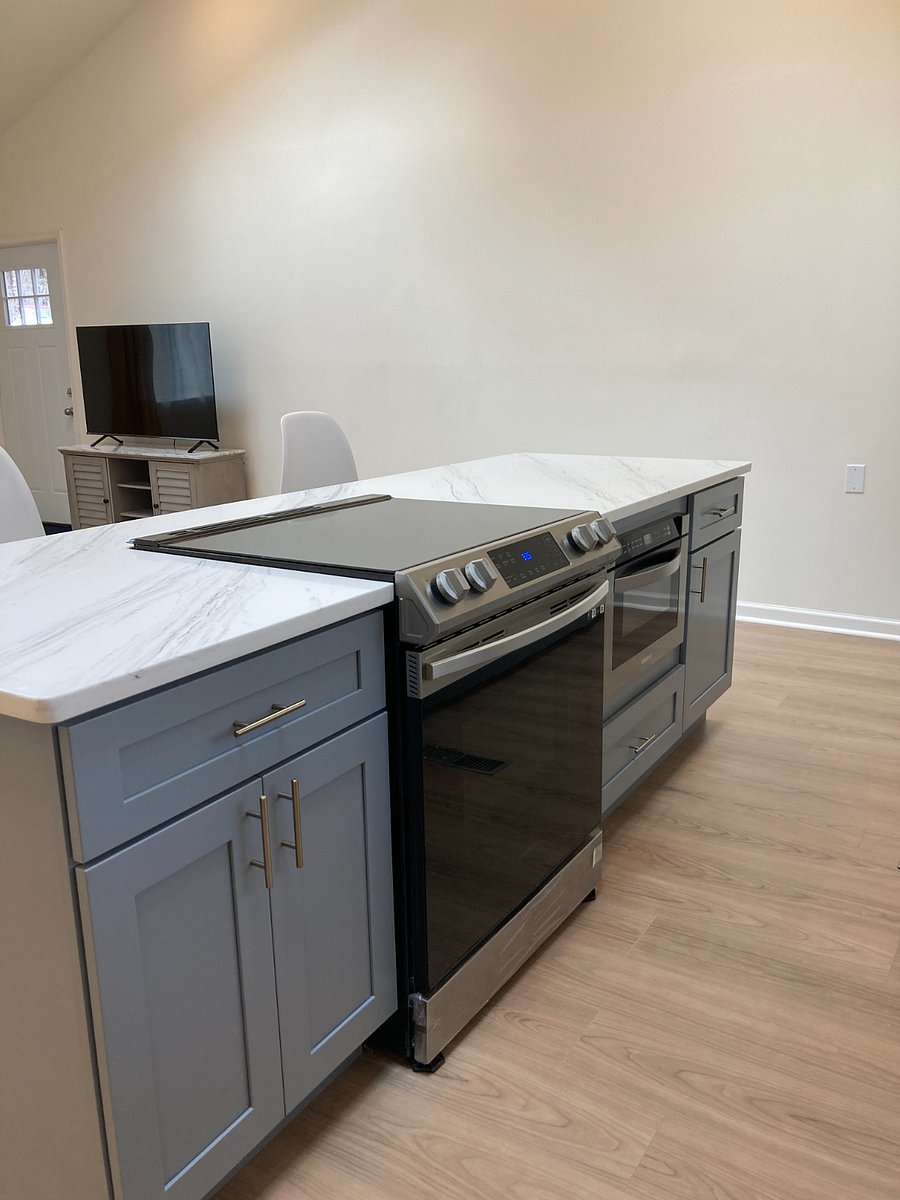 Kitchen island with built in range, drawer microwave, and overhang for dining