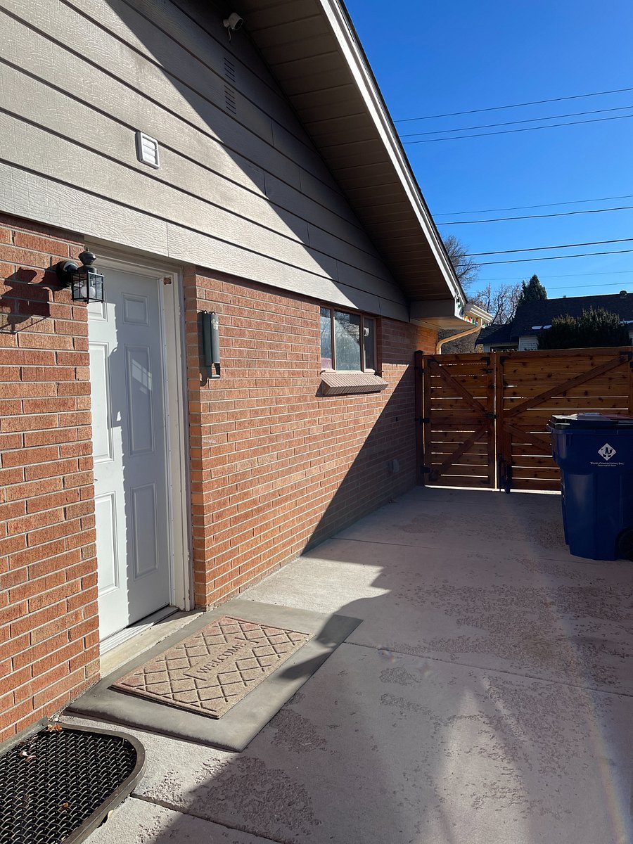 Small patio between the entry gate and the side door leading downstairs to the apartment.