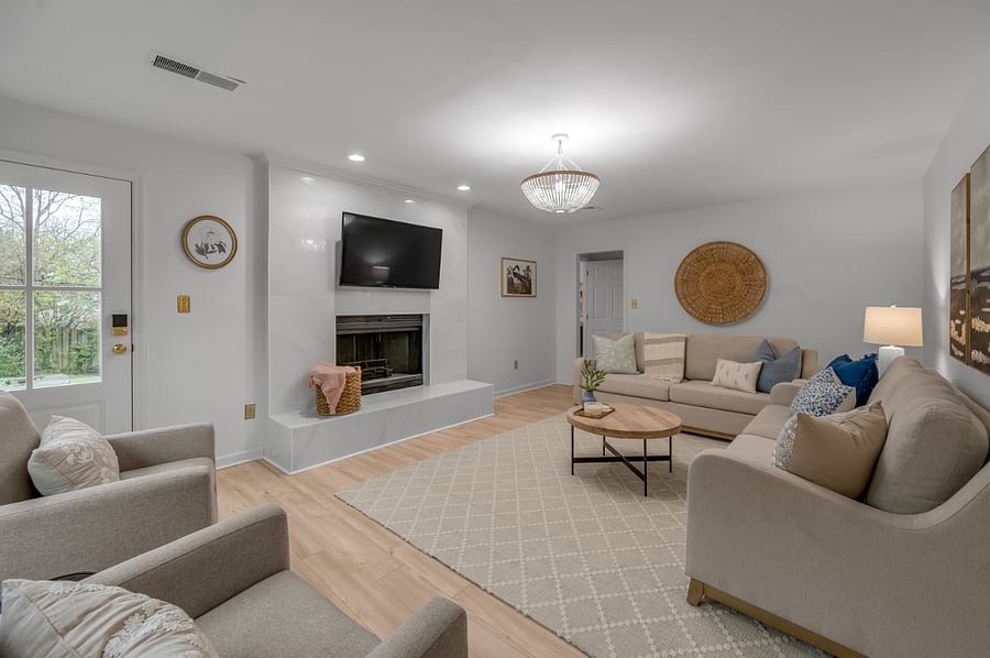 Living room with brand new smart TV, furniture and decor. Door on left leads to completely fenced back yard with two raised garden beds ready for your seasonal garden.