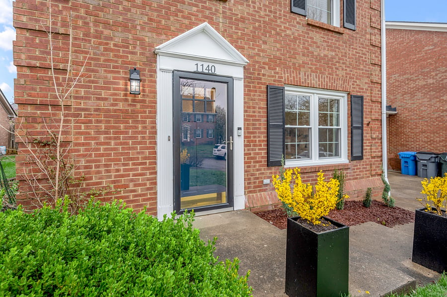 Front entry with keypad for secure keyless entry. One-car garage is on right side of photo along with single lane driveway.