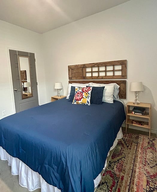 2nd bedroom with queen bed, nice size closet, luggage rack and standing fan.