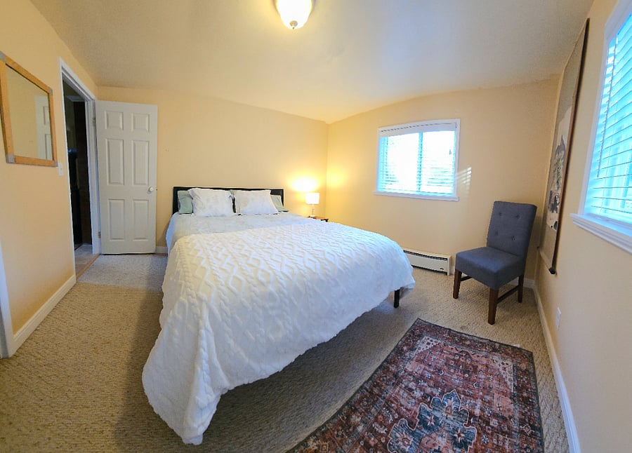 Bedroom 2 with Queen Bed, chair, large closet, and chest of drawers.
