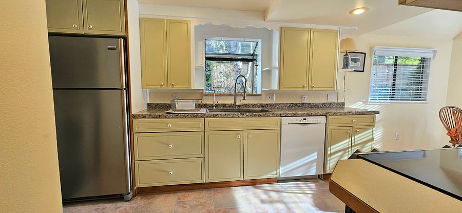 Refrigerator, new Bosch dishwasher, farmhouse stainless sink, dishwater, coffee cups, wine glasses, and plenty of kitchen storage.