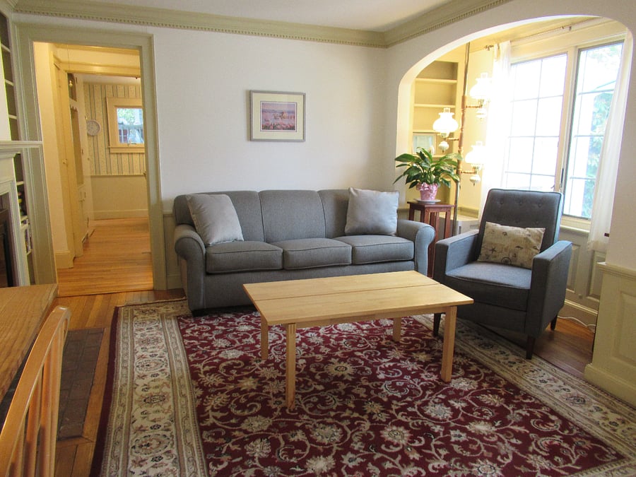 Living room couch, reading nook, recliner. There is another recliner in the room