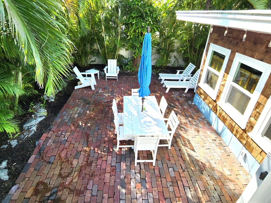 Cozy cottage feel with lush landscaping and large patio are with lounge and dining areas, outdoor kitchen and firepit