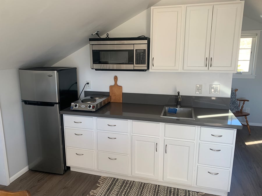Kitchenette has a sink, convection/microwave oven, compact fridge/freezer, commercial electric table cook top.