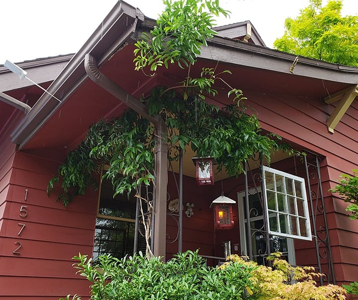Front porch of main house. However, guests self Check In entering from the sidewalk stepping stones into the side yard.