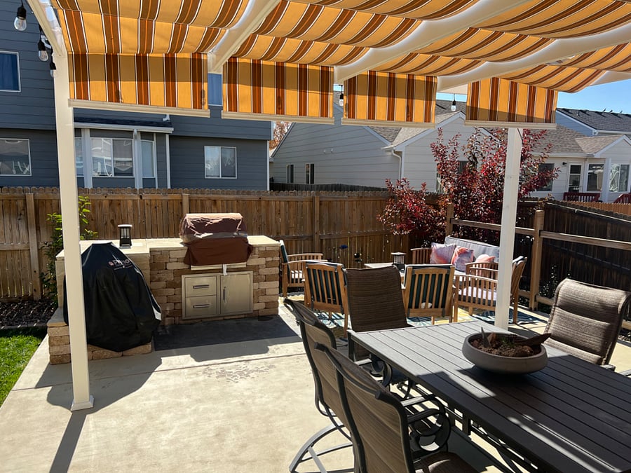 Backyard patio with outside kitchen, table and chairs and outdoor living area