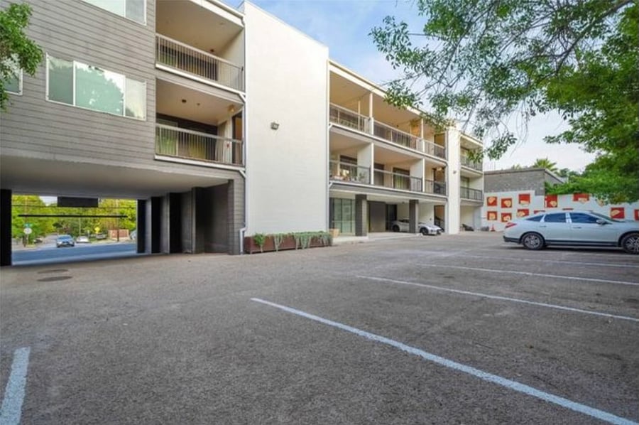 Parking lot of complex that includes 1 assigned parking spot and a pet relief area right in the parking lot area.