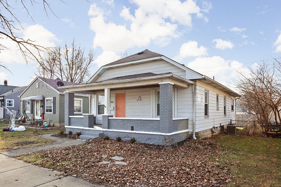 A charming bungalow with a welcoming front porch and modern gray-and-white exterior.