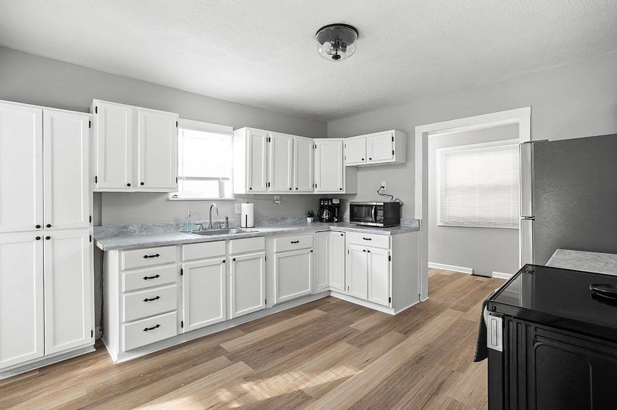 Modern and spacious kitchen with white cabinetry, stainless steel appliances, and ample natural light.