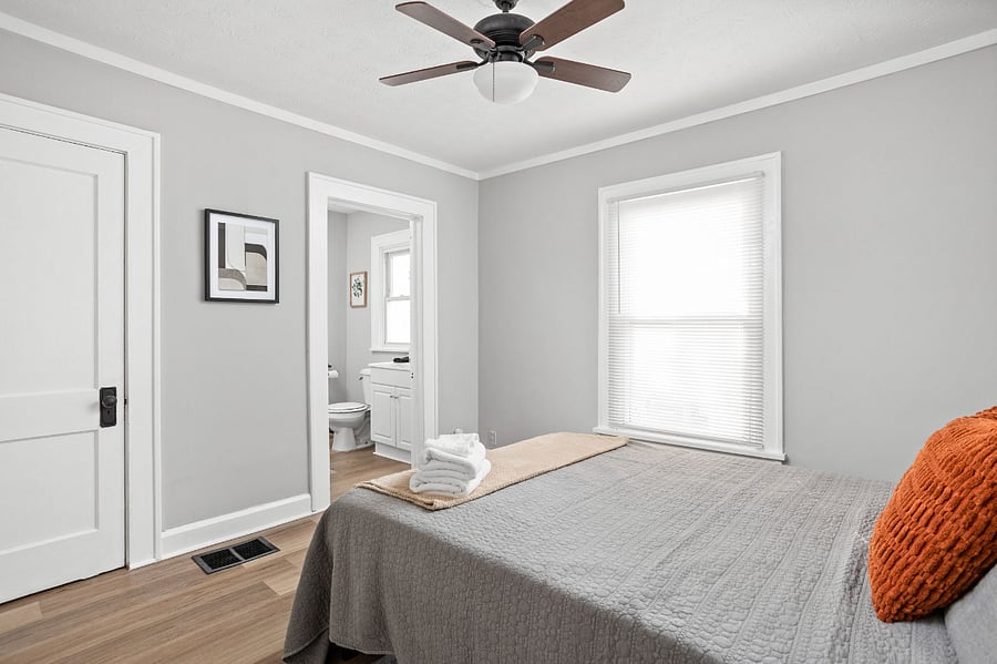 The cozy bedroom, with natural light streaming through the window, creating a warm and inviting atmosphere.