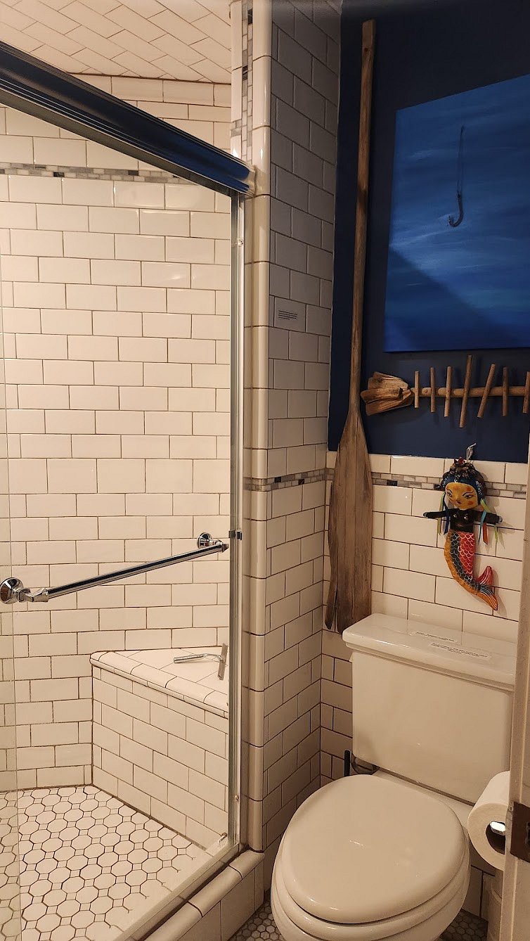 Fully tiled shower and toilet  sepatated by pocket door to main bathroom.  (there is no bathtub)