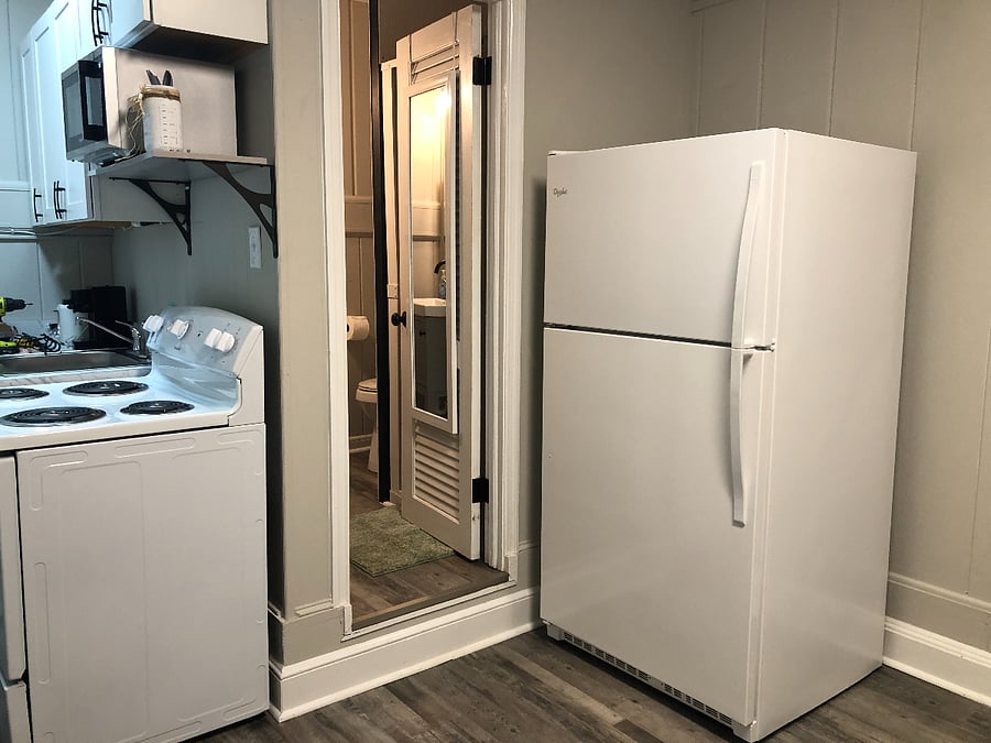 Full size kitchen with stove, microwave, coffee maker and refrigerator.