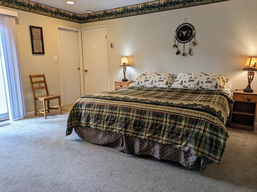Primary bedroom #1 with king size bed and sliding glass door to courtyard deck