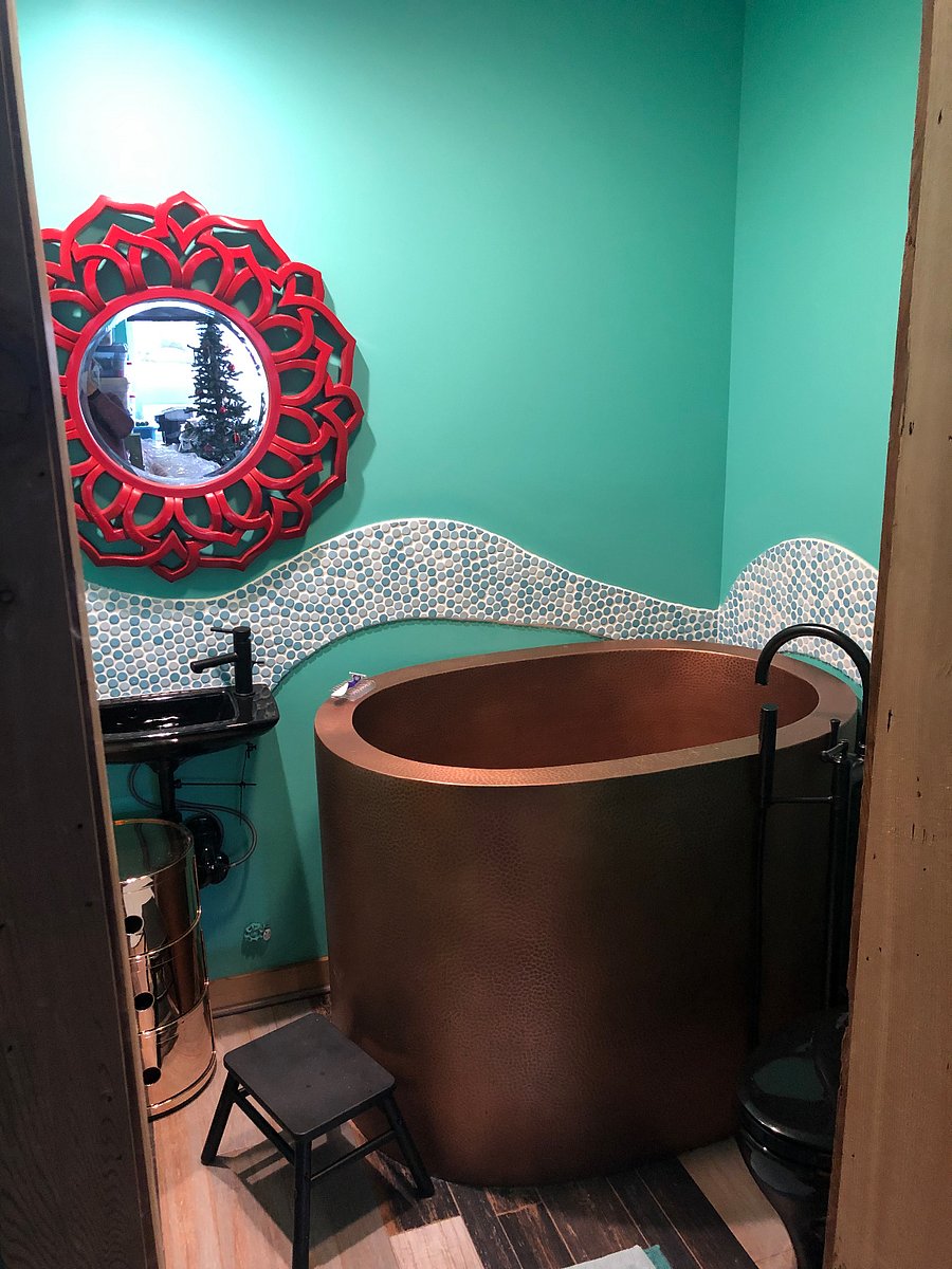 bathroom with Japanese soaking tub, handheld shower, sink, toilet