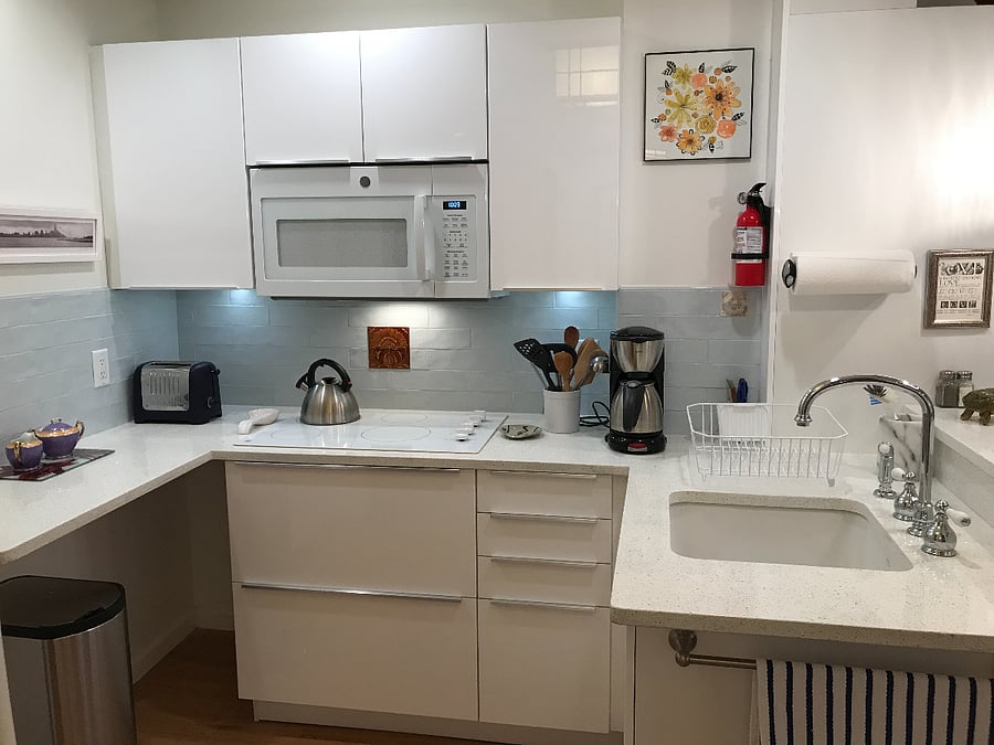 Kitchen stove, microwave, toaster over, and coffee maker. 