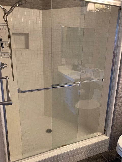 Shower stall with glass doors in attached ensuite bathroom