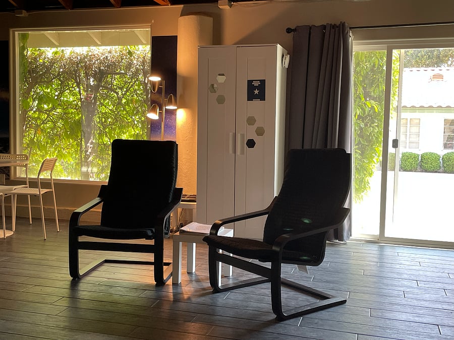 South wall of unit with picture window (privacy provided by hedge) and door leading to shared backyard.
