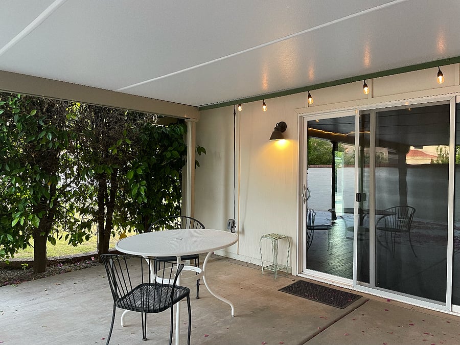 Private patio by entrance to unit under the covered parking area