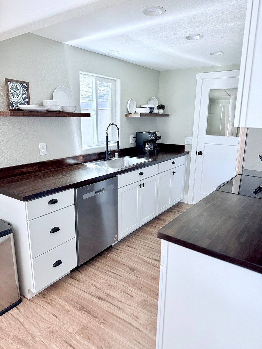Butcher block countertops, stainless steel single basin sink, floating shelves and a coffee maker for brewed or k cup coffee.