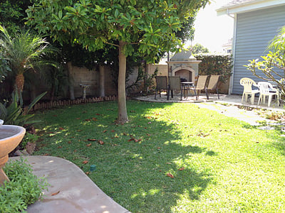 Back yard with fireplace and dining table and chairs.  Fountain on left.