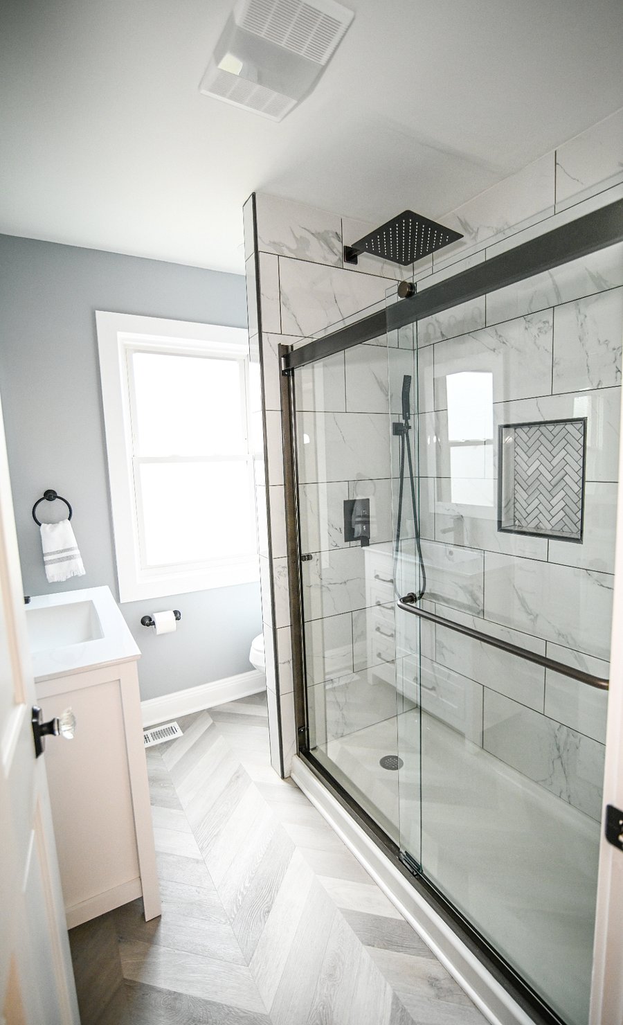 Newly remodeled bathroom with marble tile and rainfall shower head