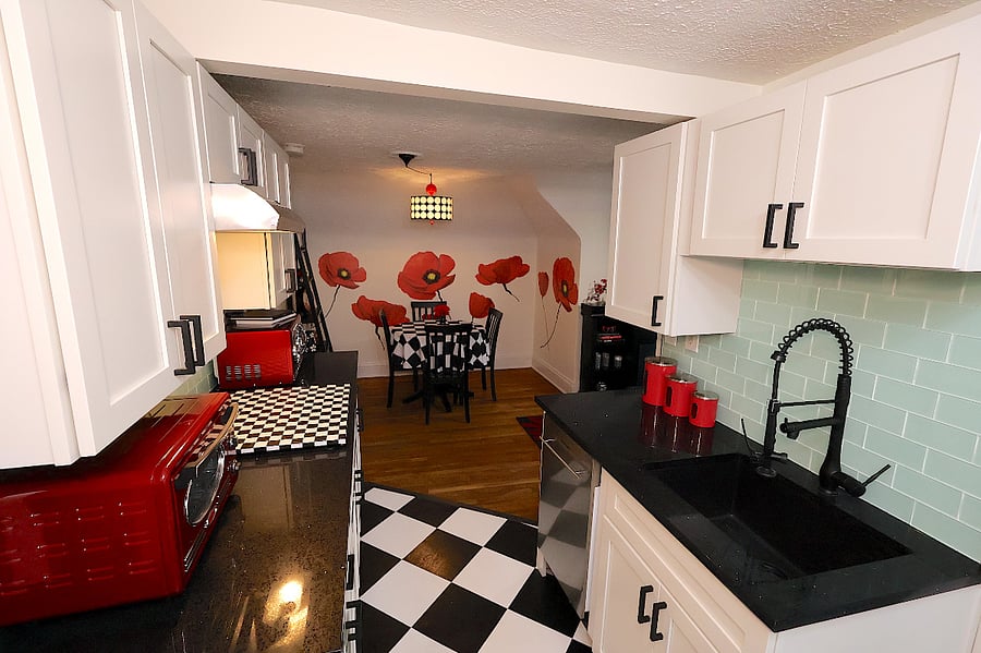 Newly remodeled kitchen with quartz counter tops, glass top induction stovetop (underneath the checkered board). Note there is no oven, but there is a microwave and combined air fryer/toaster oven.