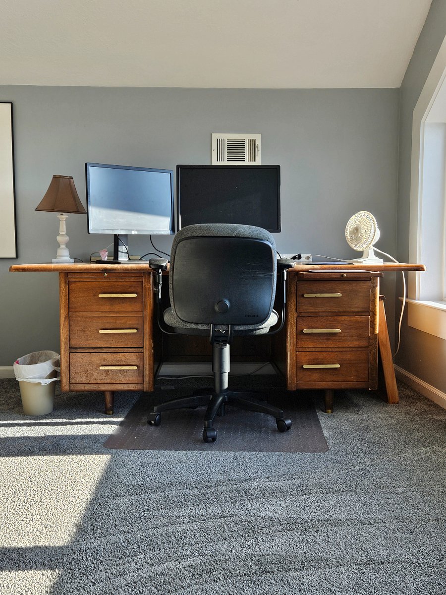 Upstairs office area with monitors, desk, and chair