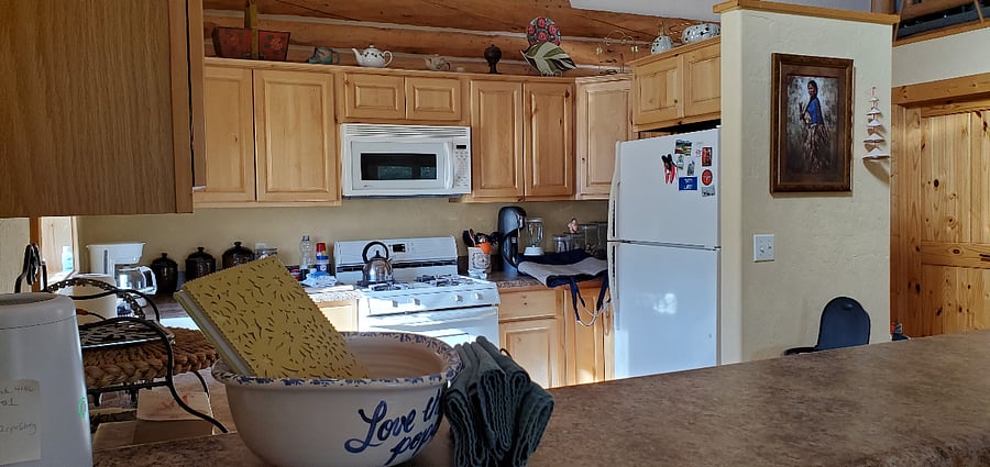 Kitchen featuring full stove, microwave and refrigerator/freezer.