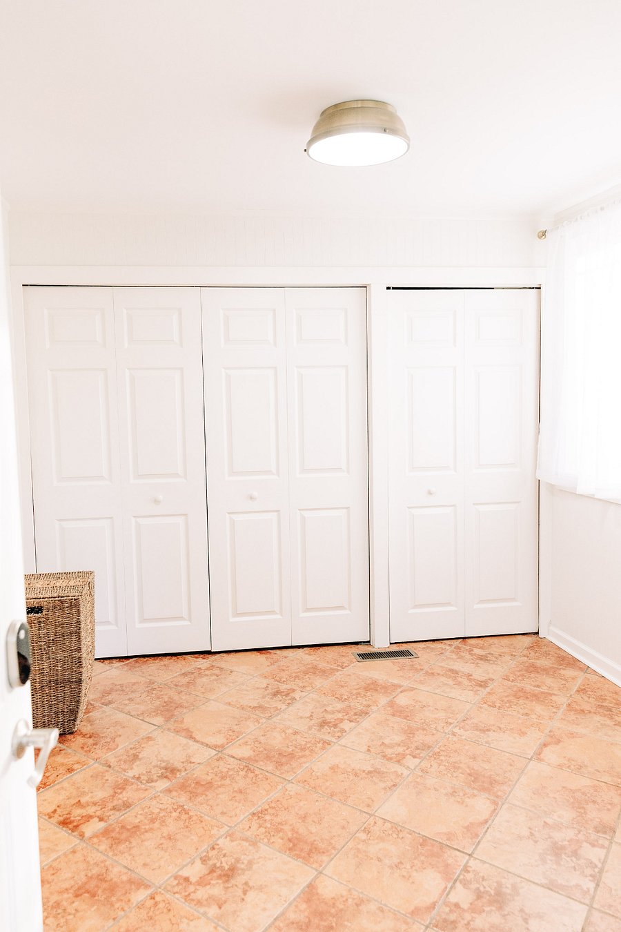 A side by side washer and dryer are hidden behind these doors in the mudroom, plus additional storage and supplies.