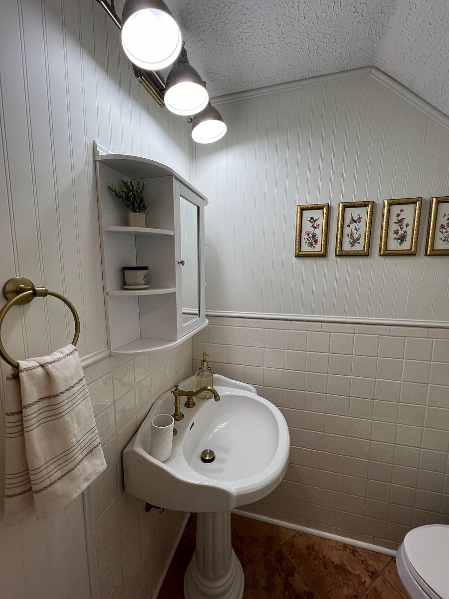 Mirrored medicine cabinet in bathroom offers additional storage.