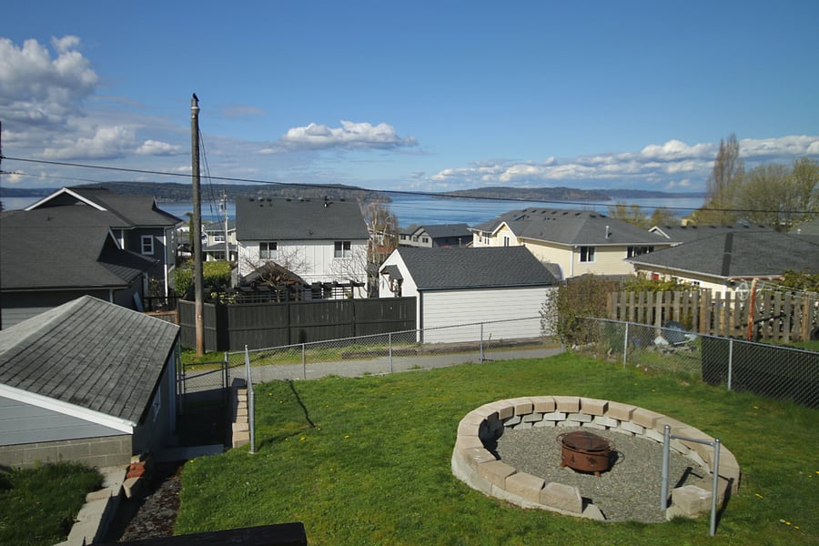 View from back porch showing back yard, fire pit, and view.