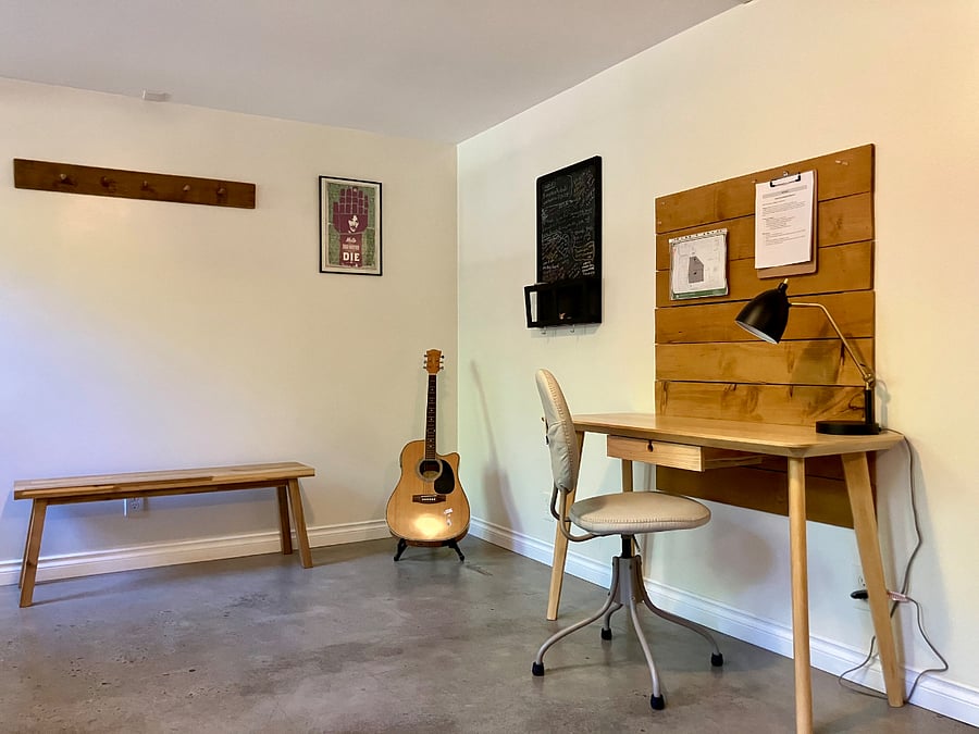 work space in a nook off the living room - comfortable chair, desk, light, outlet, and wifi