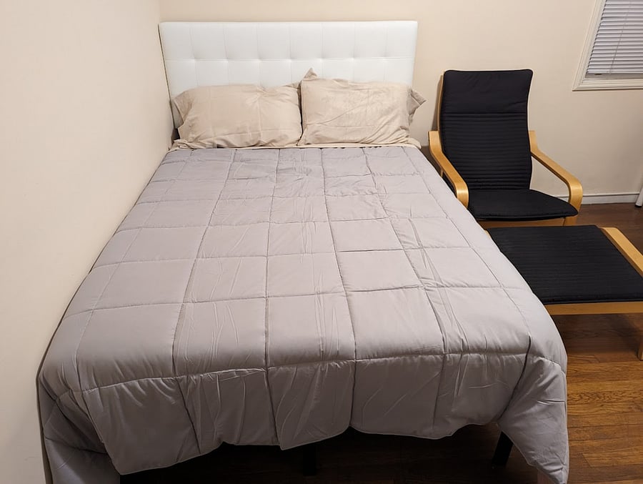 Full bed with sheets, comforter, and pillows.
