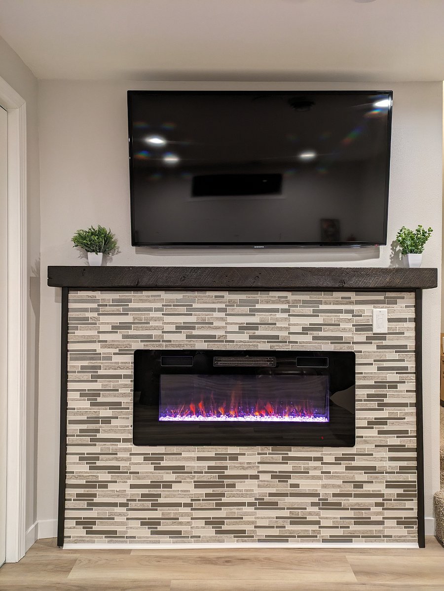 The living area features a 50-inch Samsung Smart TV that is ready to be synced with your favorite streaming platforms. The remote-controlled fireplace with the added feature of adjustable colored flames adds both warmth and ambiance to suit your preferences.