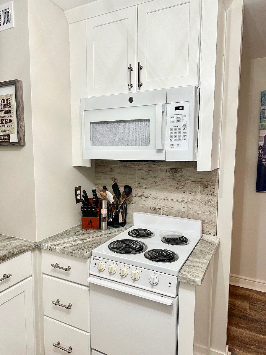 Brand new microwave with two shelves and a Magic Chef oven/ stove with ample utensils.