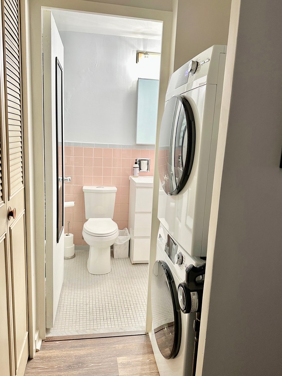 Brand new stacked washer and dryer on right and large storage closet on left, leading into the bright updated bathroom.