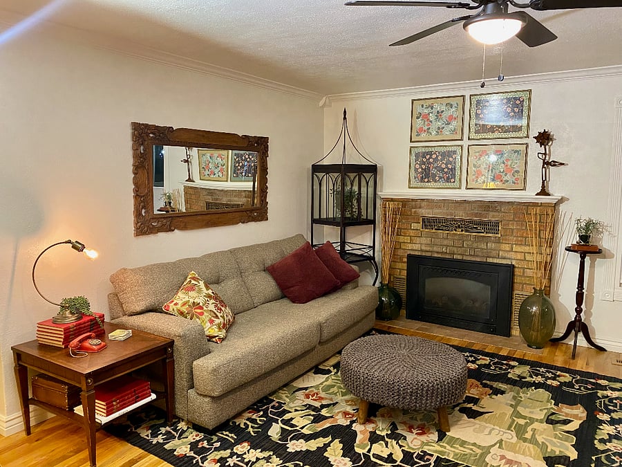 Living room with graciously sized sofa, wool rug, curated artwork.  Freshly refinished hardwood throughout the house.