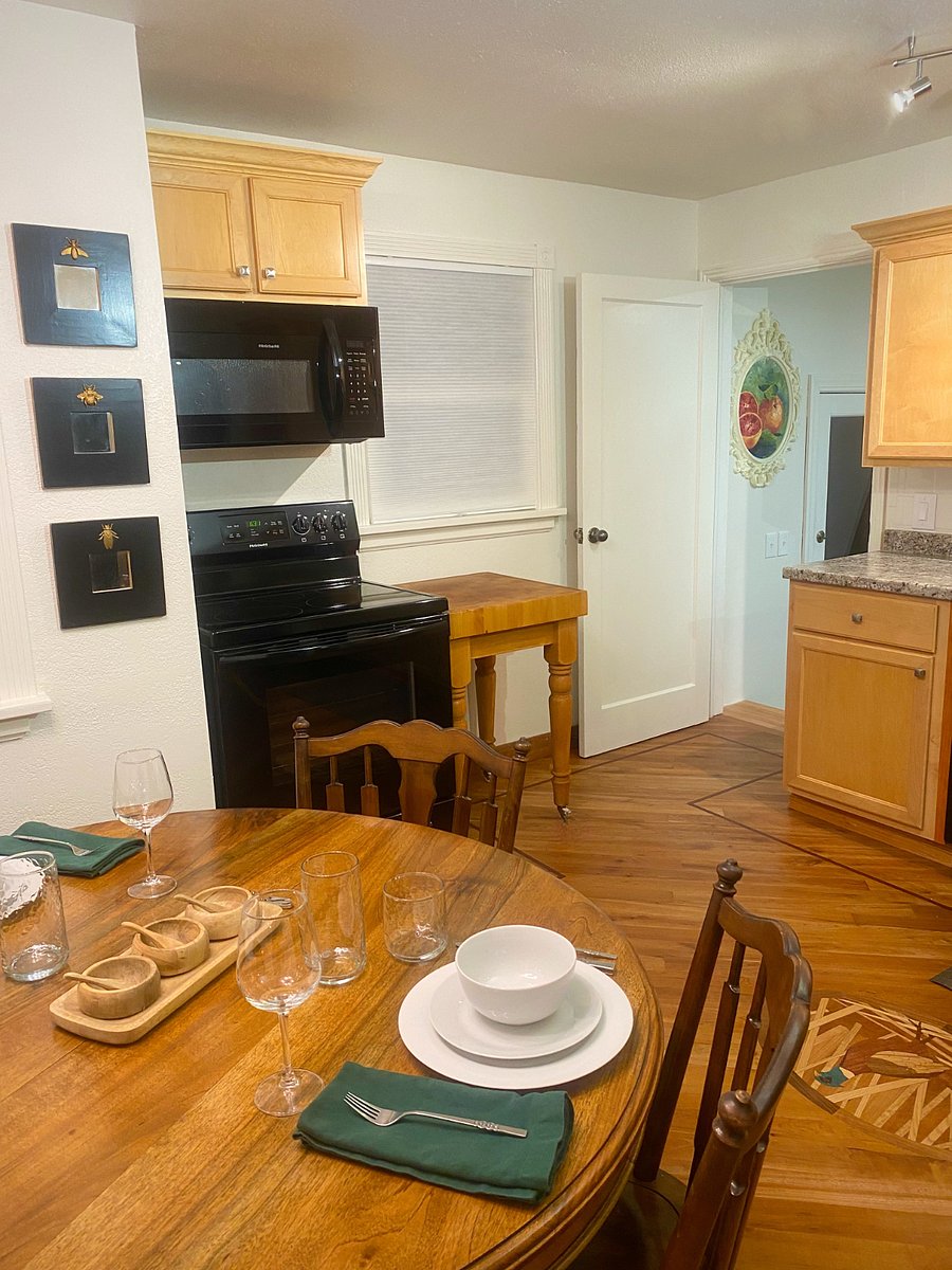 View from dining table to stove and down to mudroom and full sized laundry units.