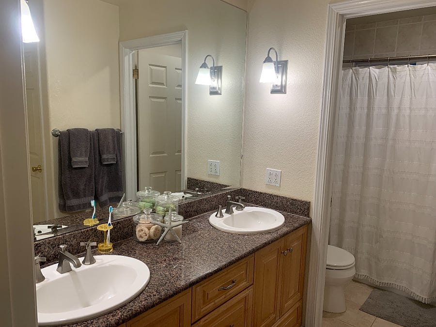 Bathroom off bedroom. Second door that separates sinks from toilet and shower/bathtub.